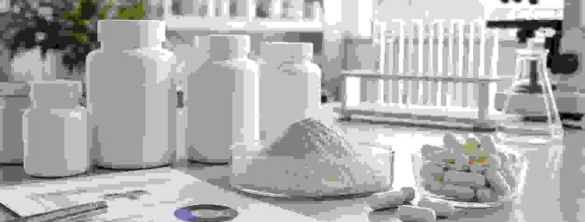 Private label lumbrokinase capsules with enzyme powder, capsule bottles, and quality documents in a lab workspace