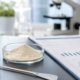 AI-generated laboratory image of lumbrokinase powder sample, quality-control chart, and microscope for nutraceutical ingredient sourcing