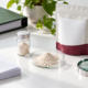 Conceptual ingredient evidence review with a sample vial, generic powder dish, blank papers, project binder, prototype pouch, and magnifying glass