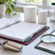 Conceptual quality review desk with sealed opaque sample containers, open blank binder, sampling scoop, magnifying glass, clipboard, and capped tubes